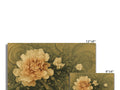 A white ceramic tile has gold foil with green and brown flowers on it.