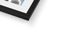 A picture frame in a white square picture frame with a reflection in it.
