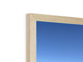 An object is placed in a picture frame on top of a wood wall.