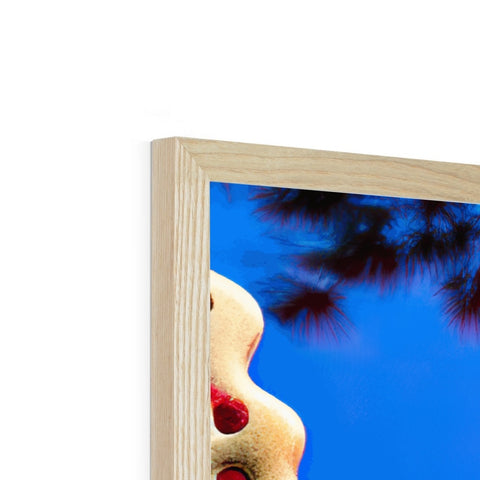 A red wooden mirror frame that is leaning next to a picture frame on a tree.