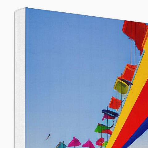 a book with a table covered in colorful kites on a sunny day
