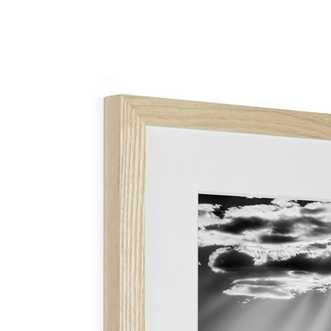 A cloud laying on top of a white background in a wooden frame