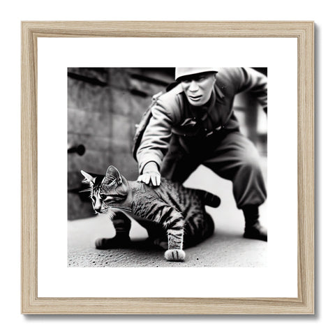 A tabby cat pats a wood framed photograph of a cat wearing a jacket.