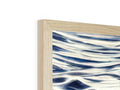 The wooden block holds up a frame with the ocean on it.