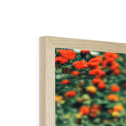 A rectangular picture frame has been wood covered in flowers, a cross section of trees,