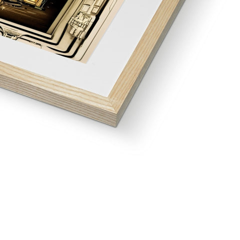 White photo with a gold and black picture in a frame on the side of a wooden