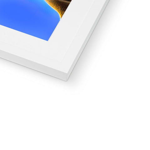 An orange and blue gold glass frame sitting on top of a wall with an imac