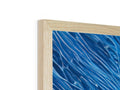 A picture frame with a blue and white picture on it has blue fabric on it.