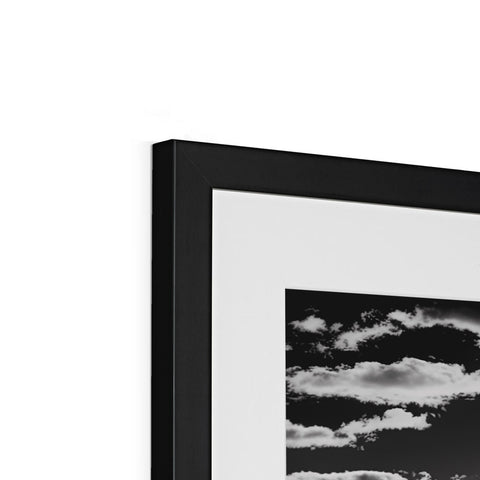 A black photo is in a frame with a frame containing an art print