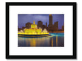 a gold framed print with a view of a city skyline and buildings.