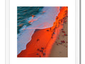 Art prints that are colorful on a beach next to large waves.