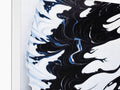 A pillow with a print image of blue waves sitting next to a light of water.