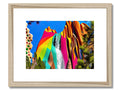 Art print of a rainbow bird flying and a rainbow umbrella sitting in some trees.