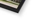 A picture of a building is held in a white print picture frame.