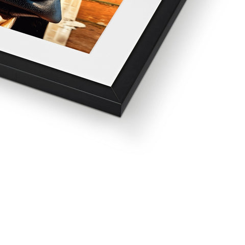 A picture frame holding a photo on a table with wooden frame.