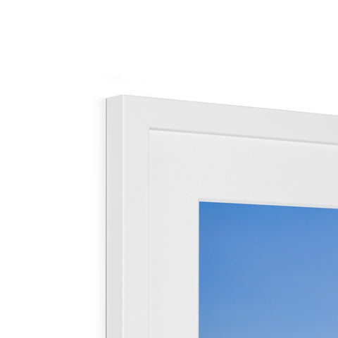 A picture frame of a window on top of two small blue computers.