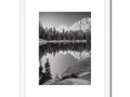 Art print sits next to a lake with snow covered mountains that look down upon the lake