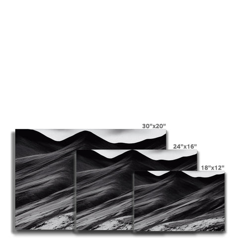 A black and white picture of colorful waves on a mountain backdrop.
