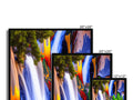 a screen on a wall displaying colorful images on 3 flat monitors.