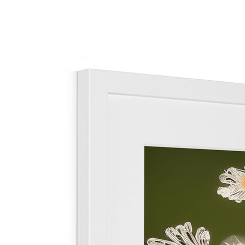 A picture frame with a picture of flowers in it on top of a white wall.