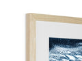 A wooden frame contains a picture of a blue and white painting in a wooden frame with