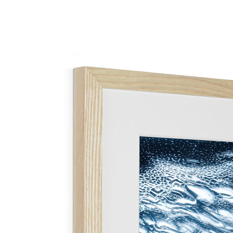 A wooden frame contains a picture of a blue and white painting in a wooden frame with