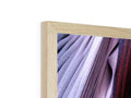 A wooden picture frame hanging on a shelf with clothes hanging on the side of it