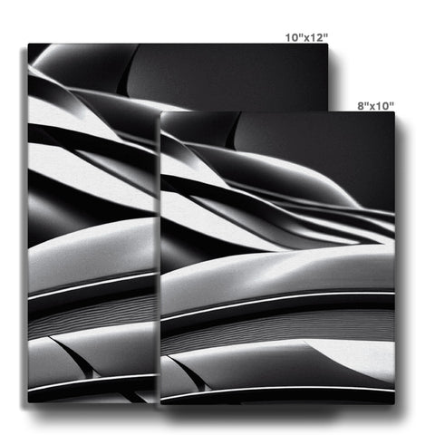 A wall with silver and black ceramic tile surrounded by a metal strip.
