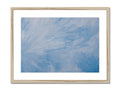 A hanging picture frame with a sky blue painting on a white background.
