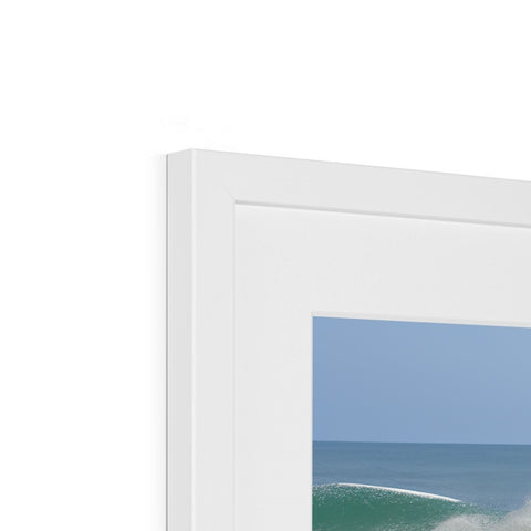 A picture frame holding a white photo that sits on top of a window.