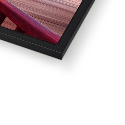 A frame of a picture on the side of a wall has wooden frame.
