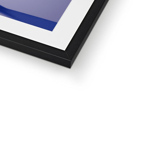 A picture frame holding a blue and black photograph on top of a window pane.