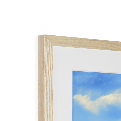 An empty white photo frame in white on a wood background.
