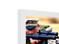 A soldier holding a rifle next to a binder with a picture in it.