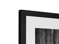 A picture frame containing black and white photos above a mirror