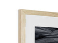 A black and white picture frame in a frame of wood with a tree.