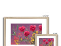 Many pink flower frames with red cushions and art prints in them.