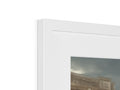 A white photo on top of a picture frame next to a box.
