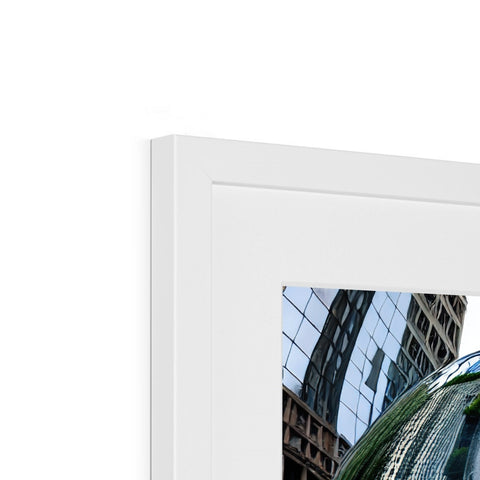 A picture frame with an open window view of a very tall building.