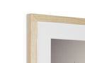 A photo is holding up a frame containing a piece of wood inside the frame.