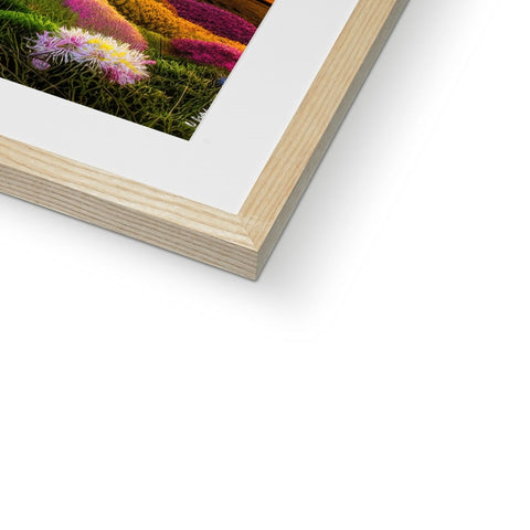 A very simple framed image on a picture front of a wall with flowers