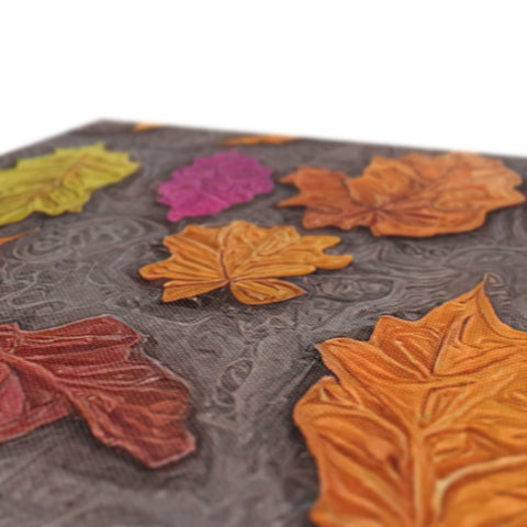 A lot of decorative paper napkins lined up with autumnal leaves in a tray next
