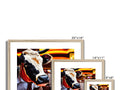 a white picture of a large cow in a colorful wooden frame,