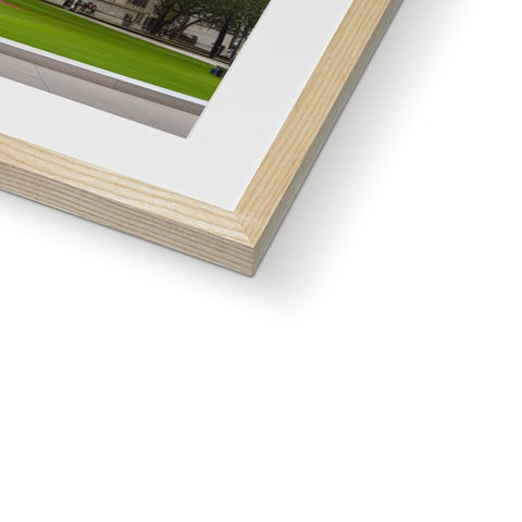 A picture of a wood frame sitting next to a wall with light green grass next to