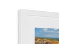A white picture with a couple of art prints painted inside a photo frame filled with some
