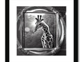 a silver and black framed picture of a giraffe in a tree