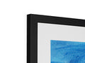 A blue and white framed picture is sitting on top of a black framed bulletin board.
