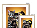 A large framed picture frame with two cats standing behind it on a black cushion.