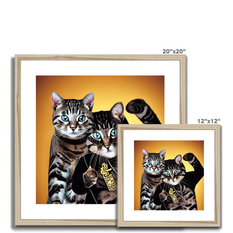 A large framed picture frame with two cats standing behind it on a black cushion.