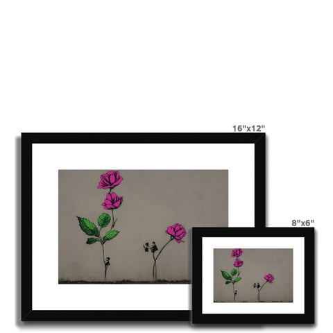 Three colored pictures on a table in a room of flowers with white and black frames.